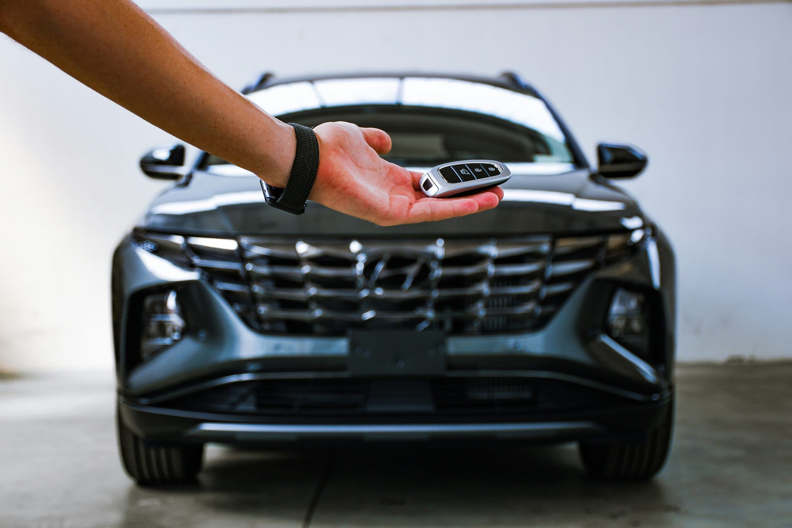 Seller holding out the key in front of a Hyundai Tucson